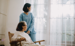 Elderly woman and nurse looking out the window