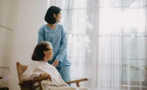 Elderly woman and nurse looking out the window