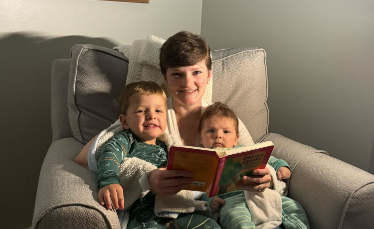 Becca Mirza holding a book, reading her two boys