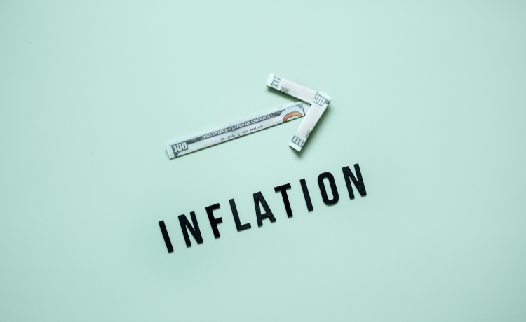 The word inflation with one hundred dollar bills made into an arrow
